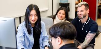 4 researchers gathered around a computer