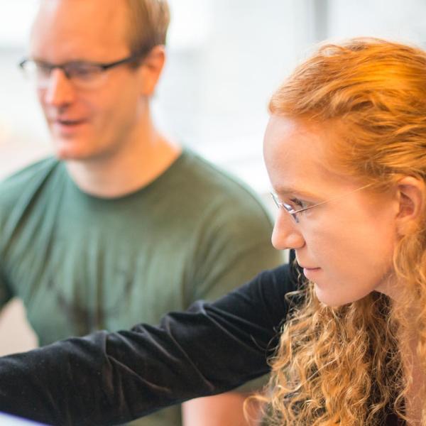Two people looking at a monitor together